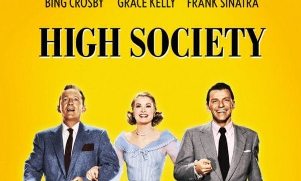 A Yellow background with Black text High Society. Actors Bing Crosby and Frank Sinatra both dressed in suits are linking arms with Grace Kelly dressed in a blue and white striped summer dress.