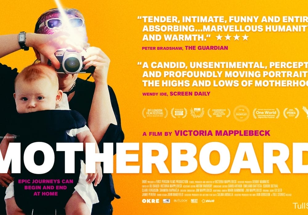 Film poster for "Motherboard," featuring a person with sunglasses and a camera, taking a picture of a baby held in a carrier; yellow background with quotes, film festival logos, and film credits.