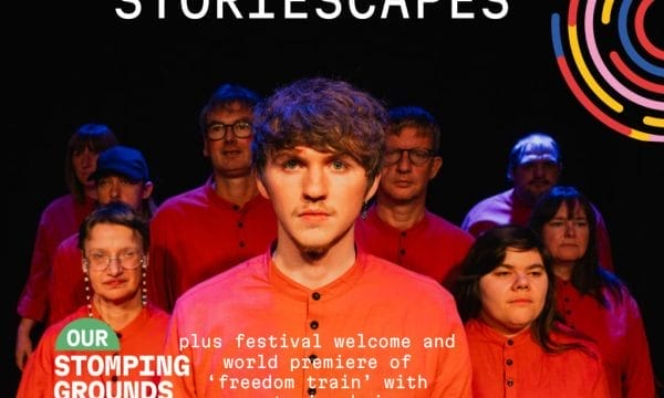 A young man stands in the middle of a group of people wearing red clothing. The white text Storiescapes is in large letters across the top of the image.