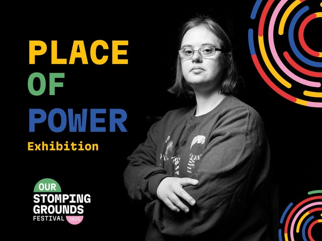 A monochrome image of a young person wearing glasses, arms folded. They have a neutral expression on their face.