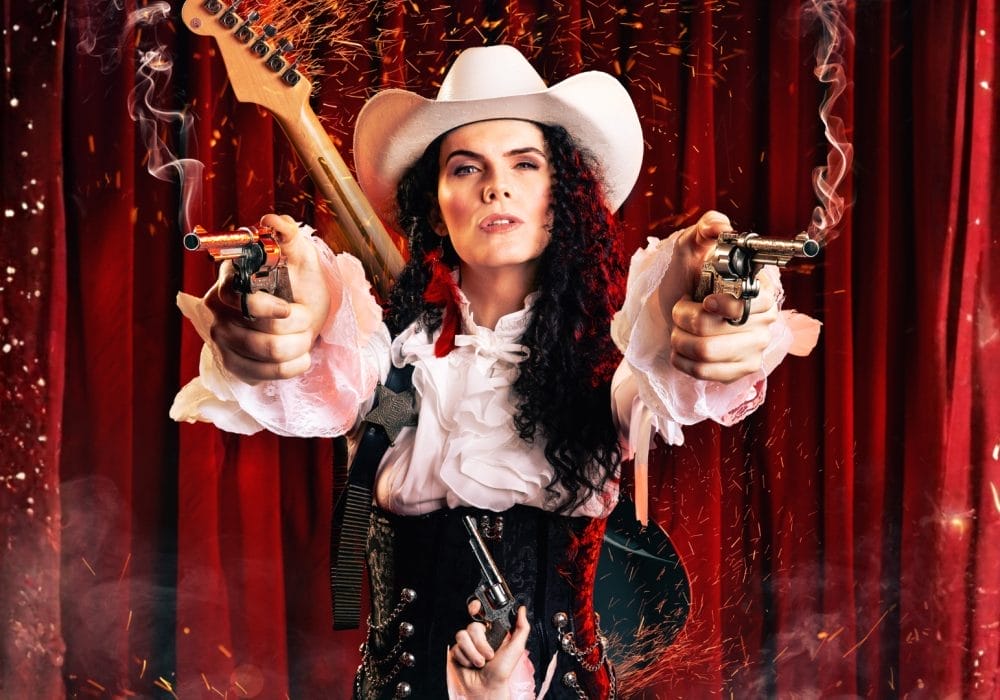 A strong and confident female wearing a cowboy hat and firing a pistol in each hand