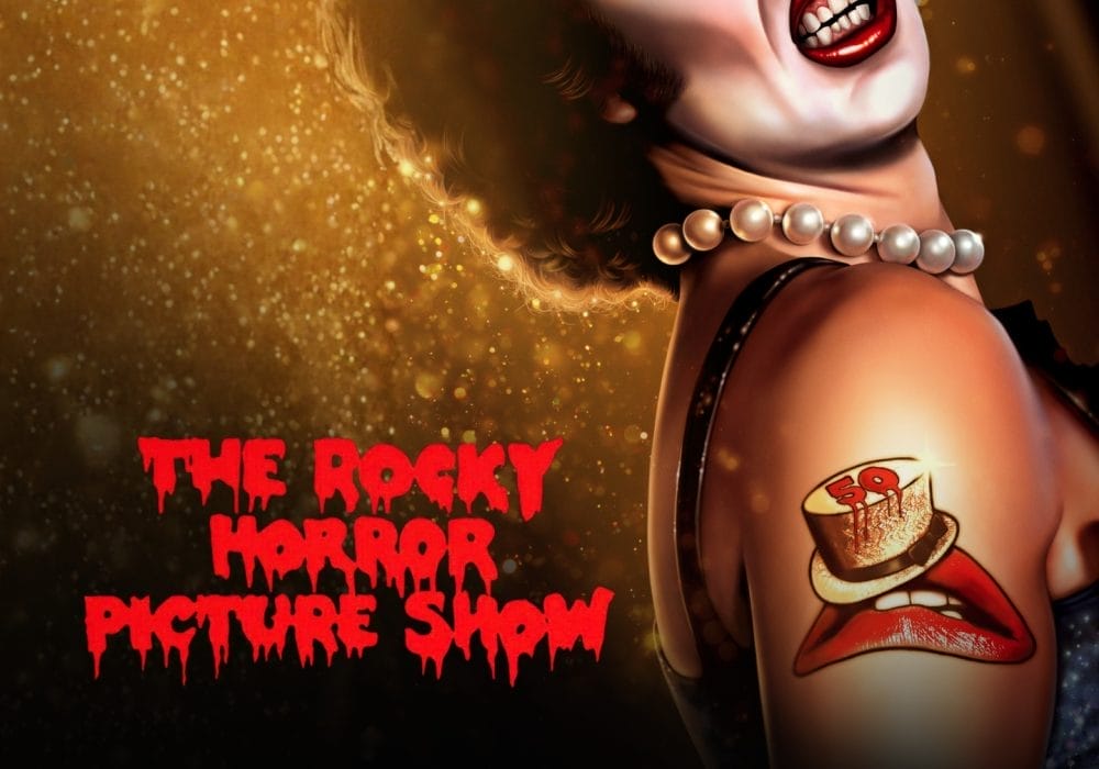 A glamourous person wearing a pearl necklace and blue sequinned outfit. Has a tattoo of a pair of red lips wearing a gold top hat. Text overlay reading The Rocky Horror Picture Show