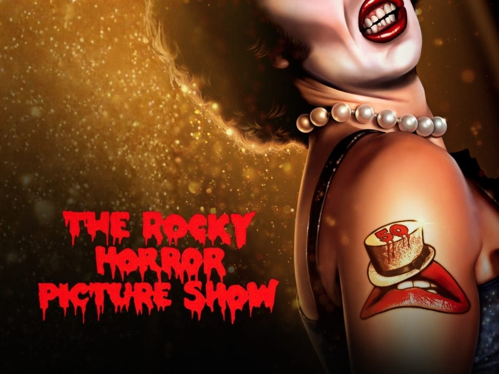 A glamourous person wearing a pearl necklace and blue sequinned outfit. Has a tattoo of a pair of red lips wearing a gold top hat. Text overlay reading The Rocky Horror Picture Show