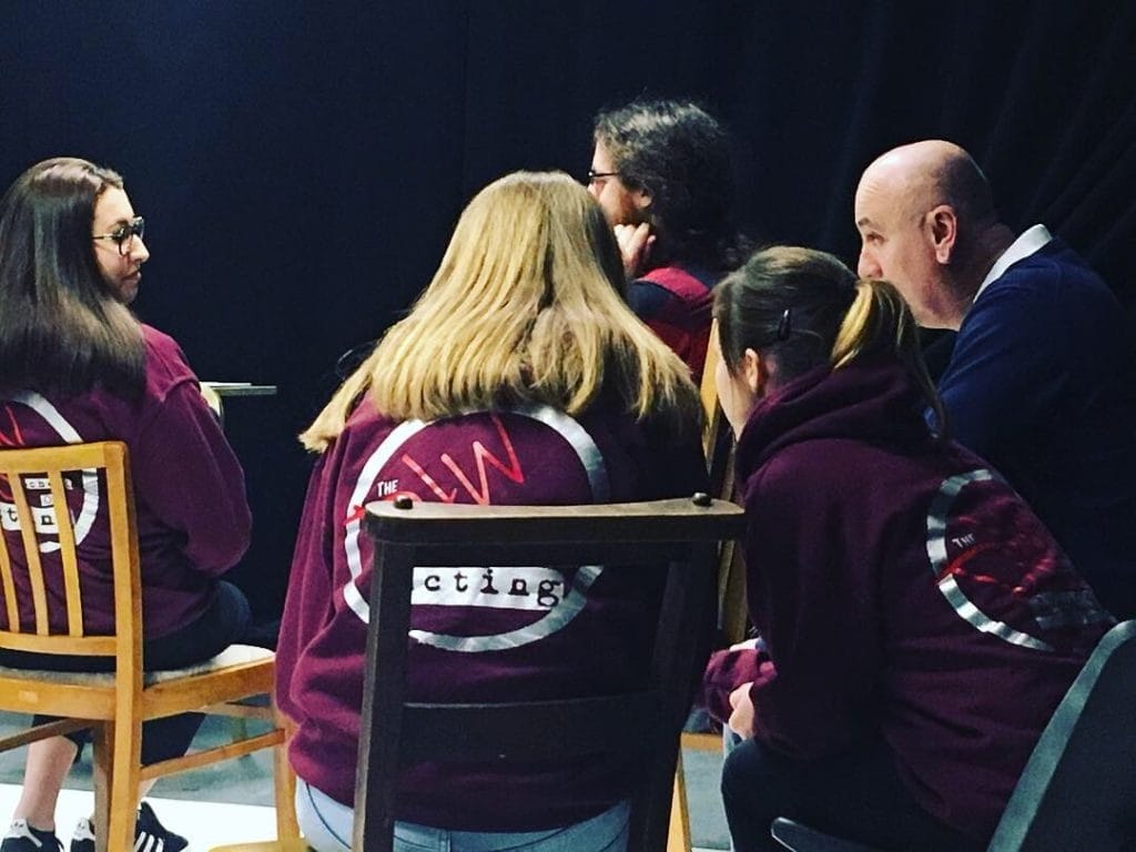 A group of actors rehearsing in a studio space
