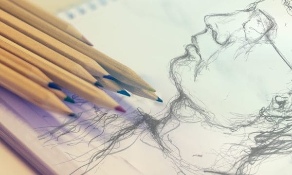 A drawing of a man's face created with various coloured pencils on textured paper.