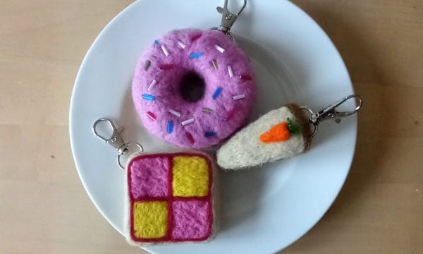 A white plate with 3 food items that have been made out of felt