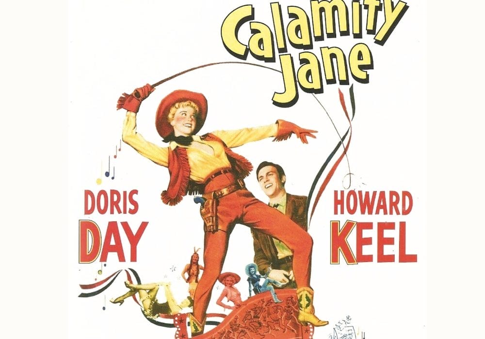 A woman dressed as a cowboy holding a whip