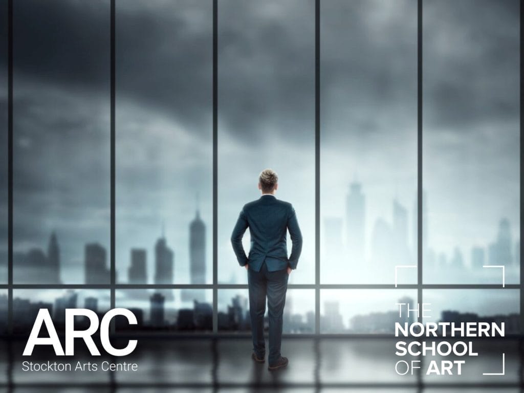 A man wearing a suit standing in front of a large window looking out at a cityscape